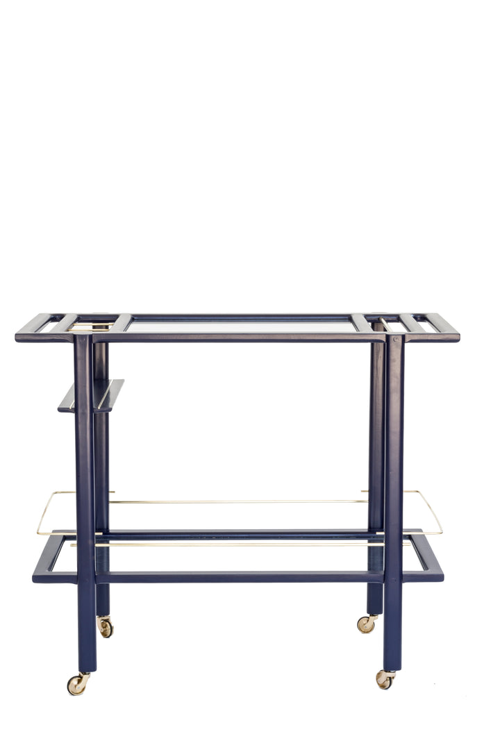 The BAR Cart from Earl Home is a solid wood bar cart on wheels with exquisite hand-cut joinery, featuring two shelves: a robust wood top and an elegant lower shelf made of tempered glass panels.