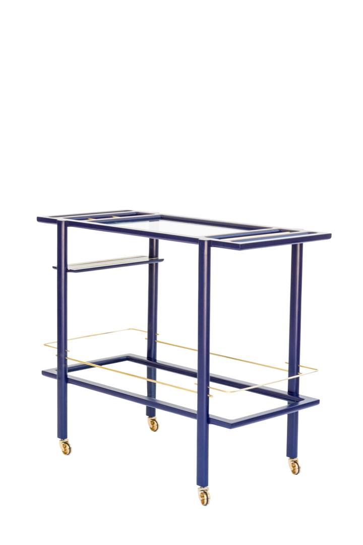 The BAR Cart from Earl Home is a solid wood bar cart on wheels with exquisite hand-cut joinery, featuring two shelves: a robust wood top and an elegant lower shelf made of tempered glass panels.