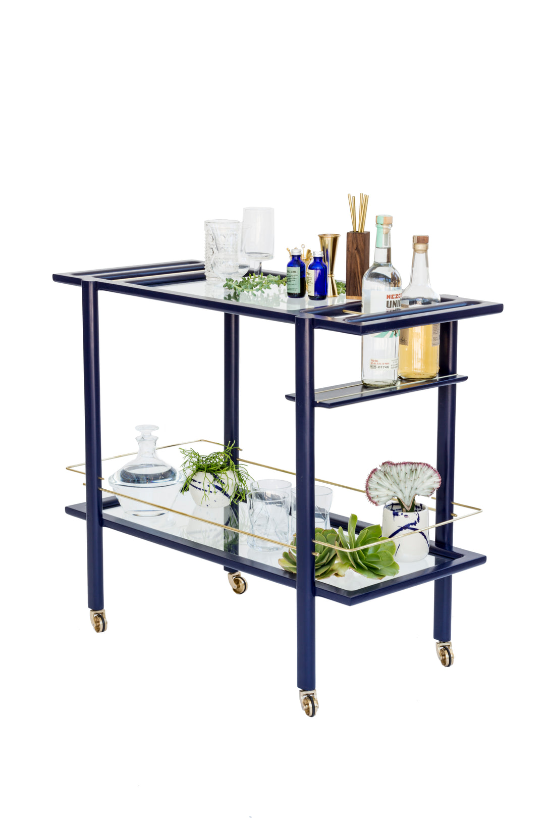 The BAR Cart from Earl Home is a solid wood bar cart on wheels with exquisite hand-cut joinery, featuring two shelves: a robust wood top and an elegant lower shelf made of tempered glass panels.