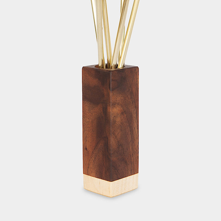 An elegant tall wooden vase with a two-tone walnut maple design graces the bar cart, displaying Earl Home's COCKTAIL Straws—thin golden rods that resemble brass.