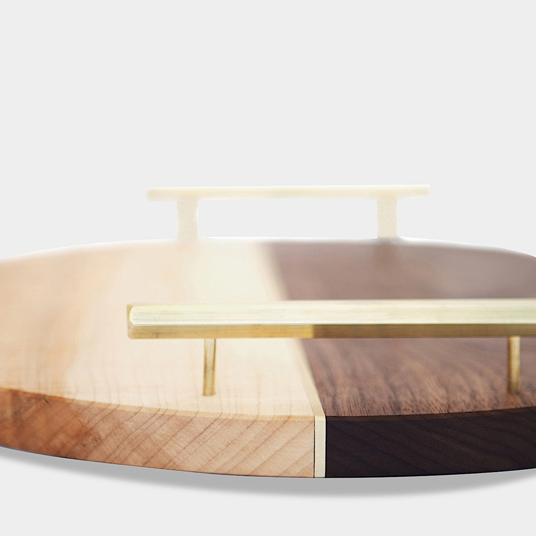 Discover the Earl Home CIRCLE Service Tray, a handcrafted piece with a round, two-tone wood design and elegant brass handles.