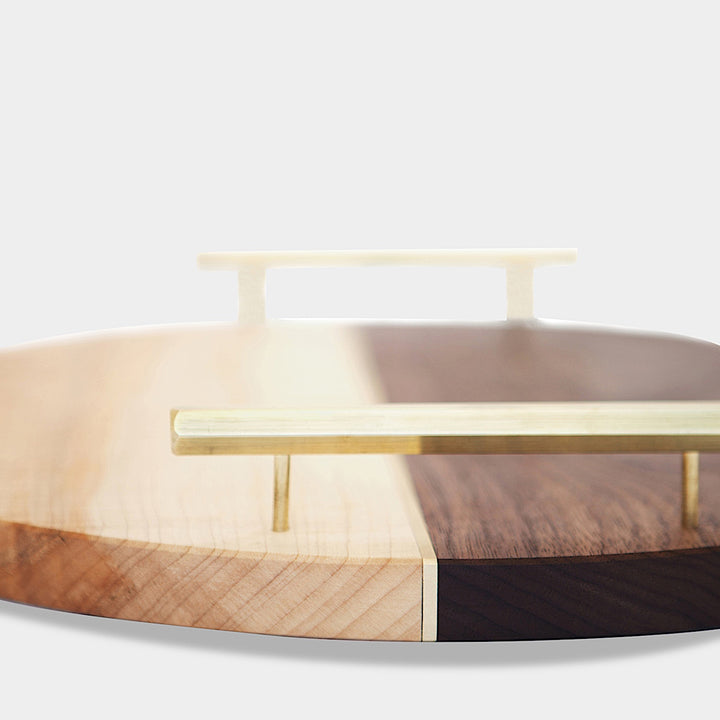 Discover the Earl Home CIRCLE Service Tray, a handcrafted piece with a round, two-tone wood design and elegant brass handles.