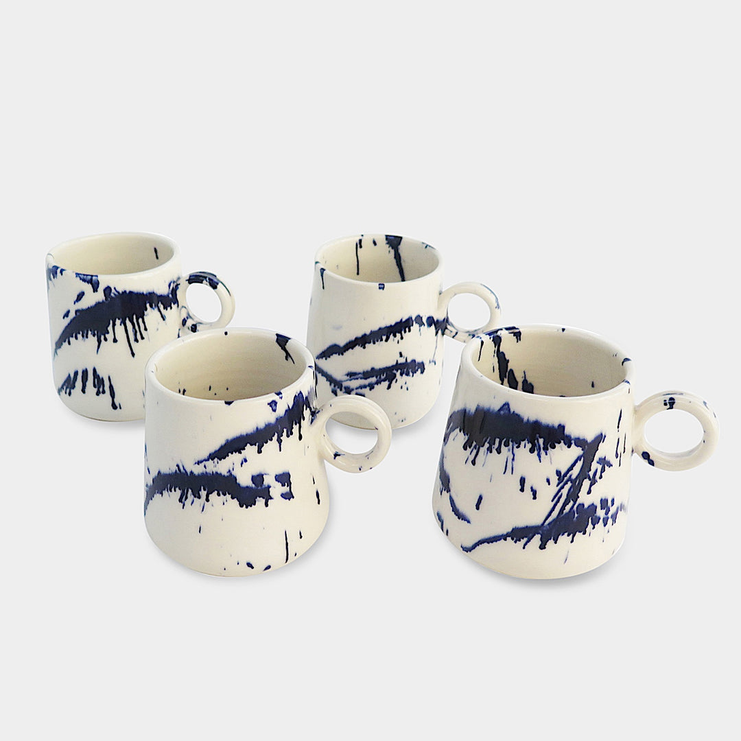 The TAPERED Mug by Earl Home is a hand-thrown white ceramic piece, showcasing a bold dark blue brush stroke and a round handle against a light gray background.