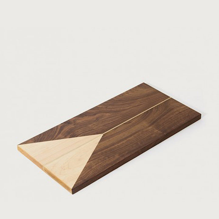 The RECTANGLE Cheese Board by Earl Home is a handcrafted serving board featuring a natural wood grain and accented with an off-center pale triangle on the left, ideal for elegant entertaining.