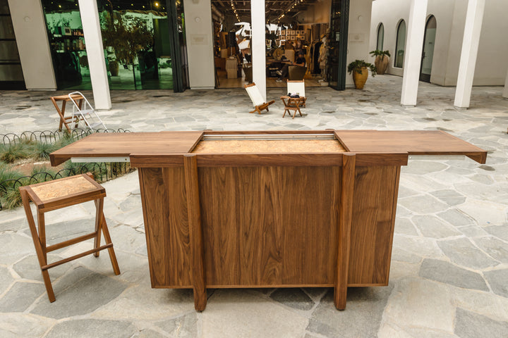 The LAPILO Folding Stool by Earl Home features a square solid wood top and cross-legged design in a sleek white finish.