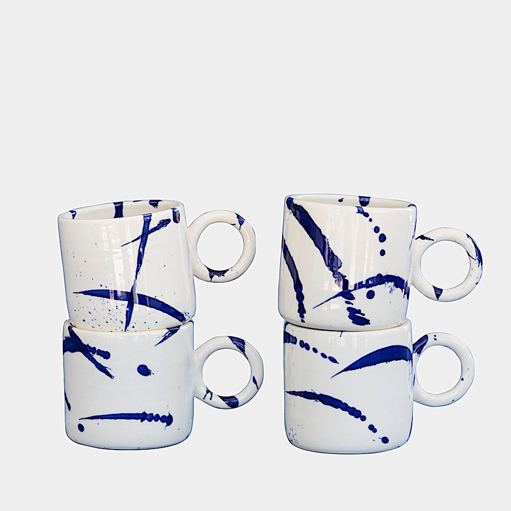 Earl Home's CIRCLE Mug is a hand-thrown white ceramic mug with black brush stroke splatters and a round handle.