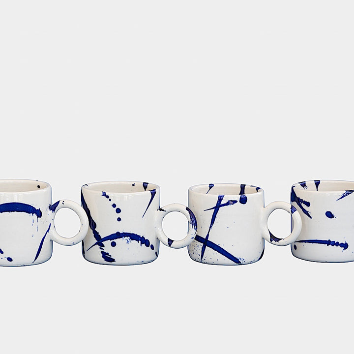 Earl Home's CIRCLE Mug is a hand-thrown white ceramic mug with black brush stroke splatters and a round handle.