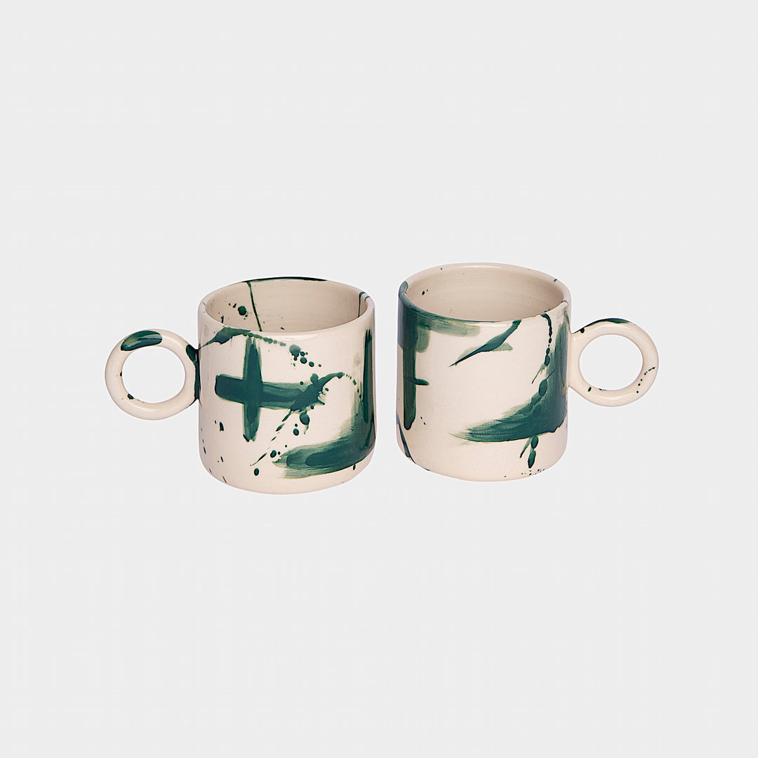 Earl Home's CIRCLE Mug is a hand-thrown white ceramic mug with black brush stroke splatters and a round handle.