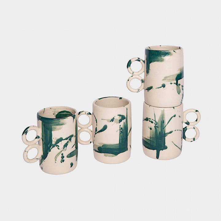 The Earl Home DOUBLE Handle Mug set includes two brown ceramic mugs, each featuring a unique round handle and white abstract patterns. Hand-thrown for artisanal charm, these mugs are perfect for those who appreciate the delicate artistry of ceramic craftsmanship.