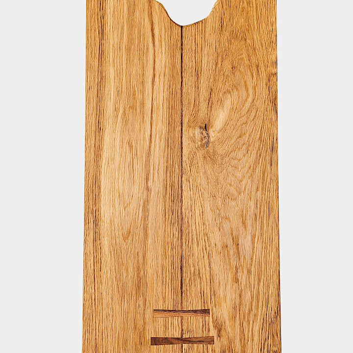 The LIVE EDGE Cutting Board by Earl Home, featuring a stunning live-edge design and natural grain finish, stands upright against a light gray background.