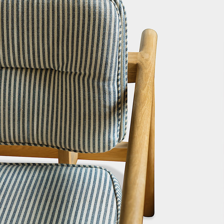 Side view of the Earl Home White Oak MORESBY Lounge Chair with blue and gray Perennials Tatton Stripe cushions, set against a plain background.