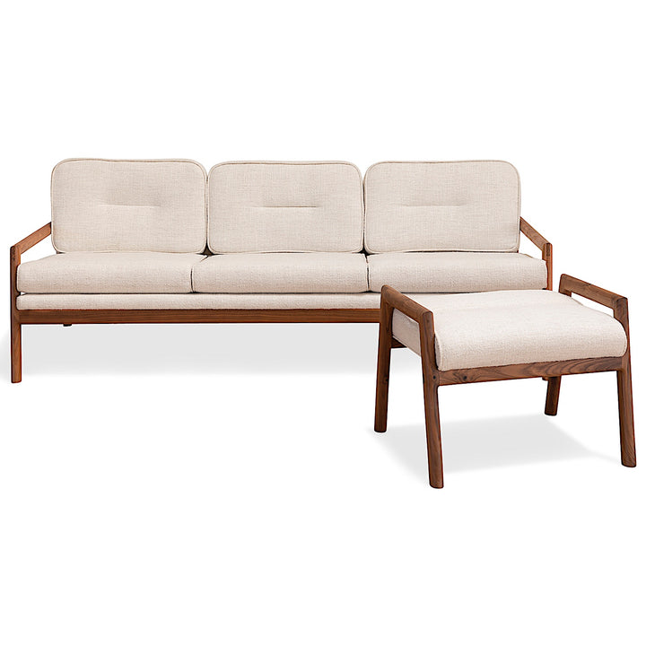 The MORESBY Ottoman by Earl Home is a handmade, custom order wooden stool with a light beige upholstered seat on four legs, set against a plain white background.