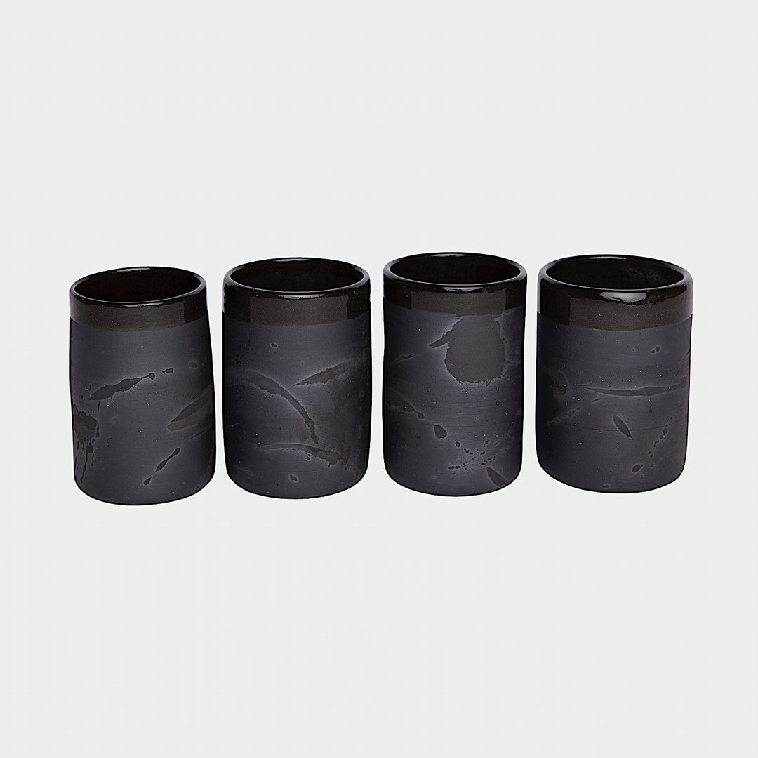 Four EARL Cups from Earl Home, featuring hand-thrown brown ceramic with unique white splashes, are arranged in a row against a plain background.