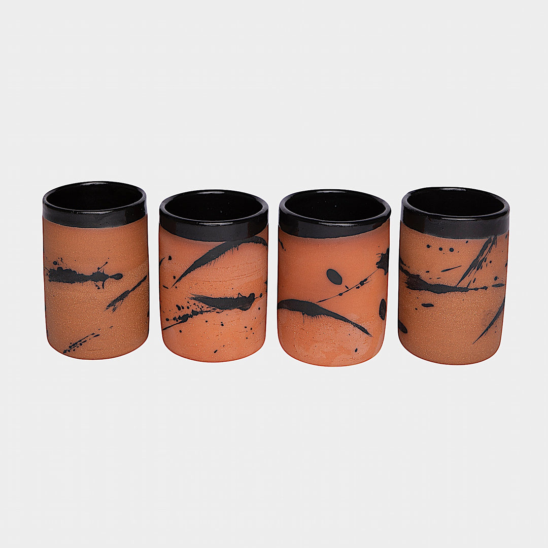 Four EARL Cups from Earl Home, featuring hand-thrown brown ceramic with unique white splashes, are arranged in a row against a plain background.