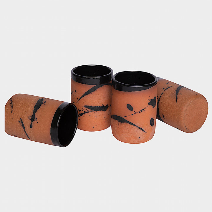 Four EARL Cups from Earl Home, featuring hand-thrown brown ceramic with unique white splashes, are arranged in a row against a plain background.