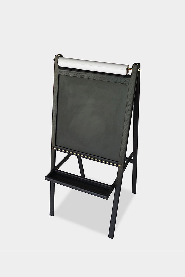 The KIDS Easel by Earl Home is a freestanding kids' easel made from sustainably sourced hardwood, featuring a chalkboard surface and a paper roll at the top.