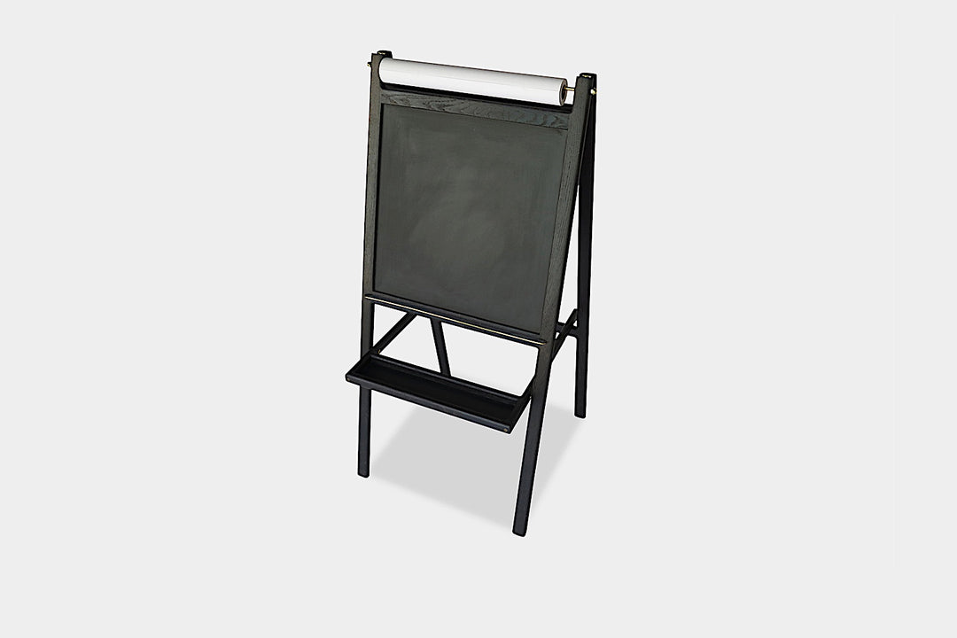 The KIDS Easel by Earl Home is a freestanding kids' easel made from sustainably sourced hardwood, featuring a chalkboard surface and a paper roll at the top.