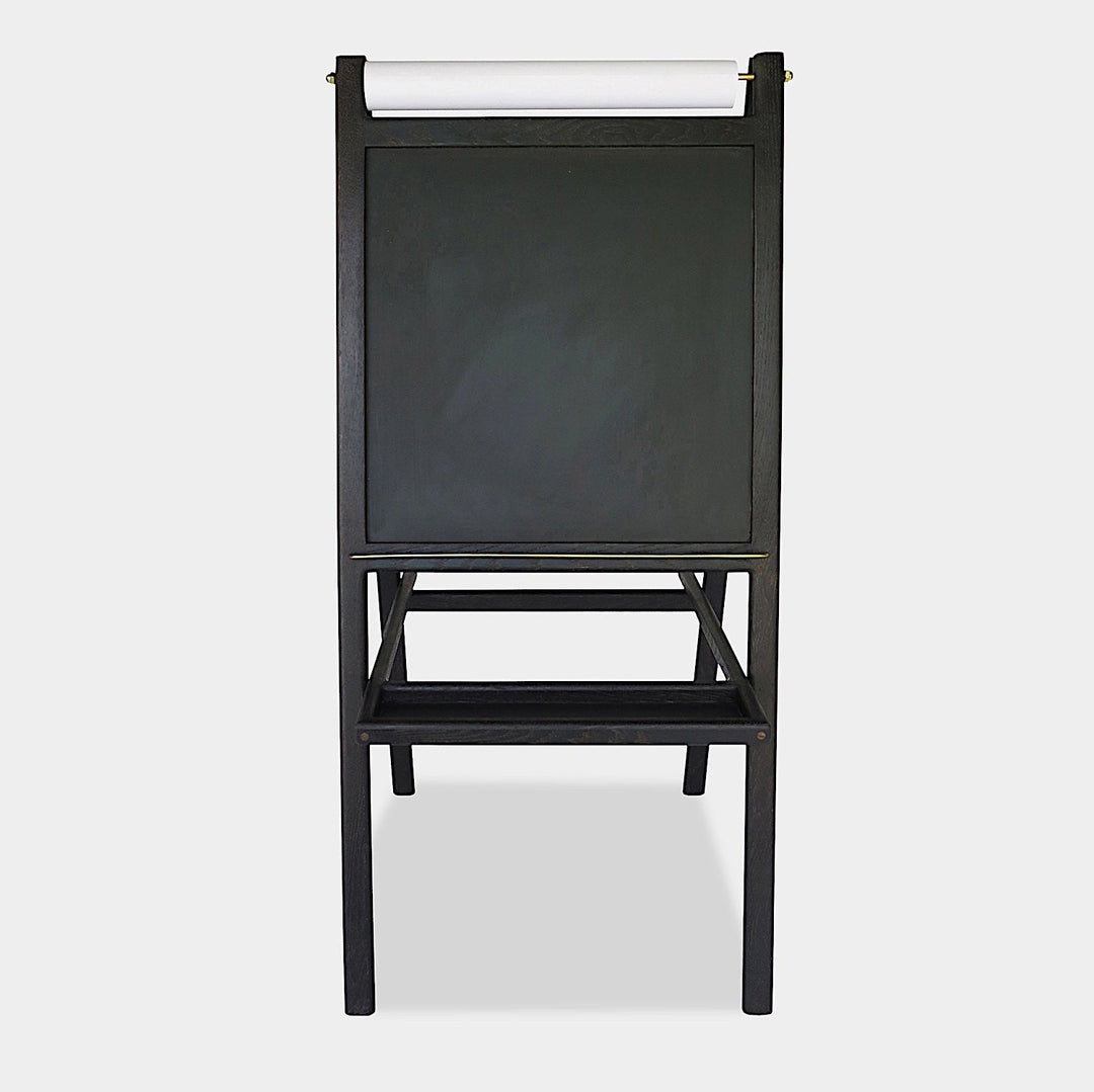 The KIDS Easel by Earl Home is a freestanding kids' easel made from sustainably sourced hardwood, featuring a chalkboard surface and a paper roll at the top.