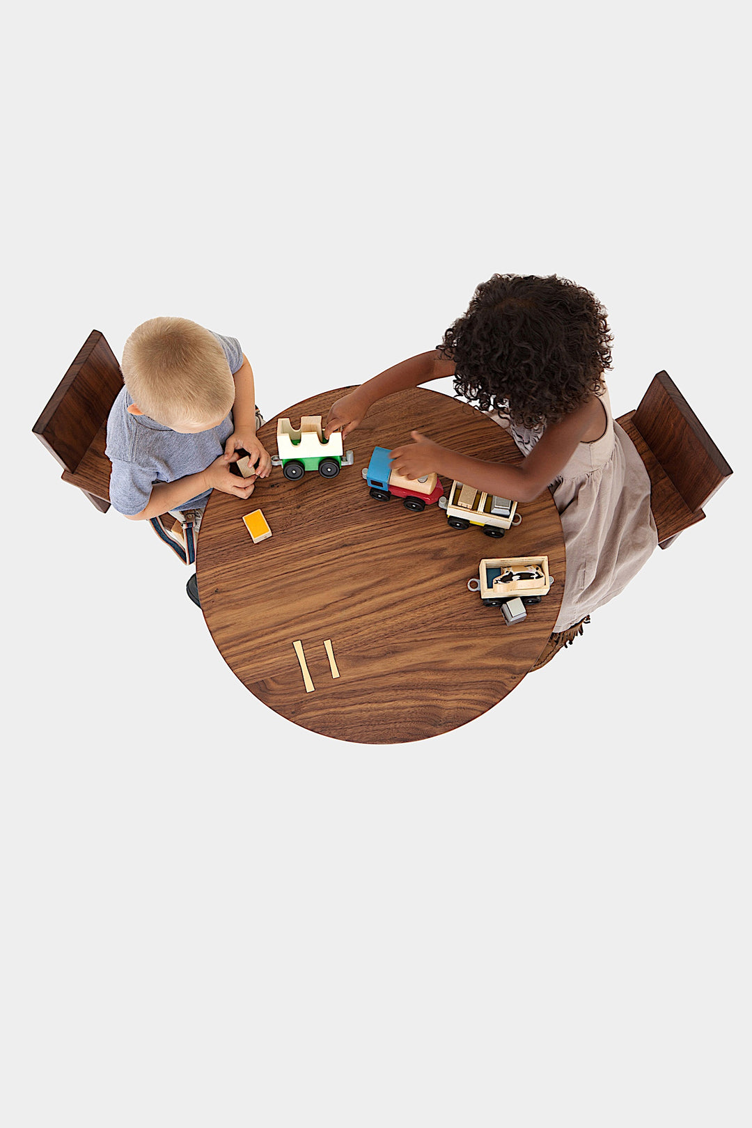 A top view showcases the Earl Home KIDS Set, featuring a custom, round wooden table made from sustainably sourced American hardwood. Two rectangular chairs are ideally positioned on opposite sides for a kid's table setup.