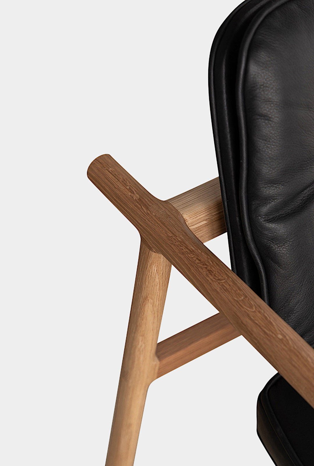 The MORESBY Captain Chair by Earl Home is hand-made with a custom upholstered seat in rich brown leather and solid wood, set against a white background.