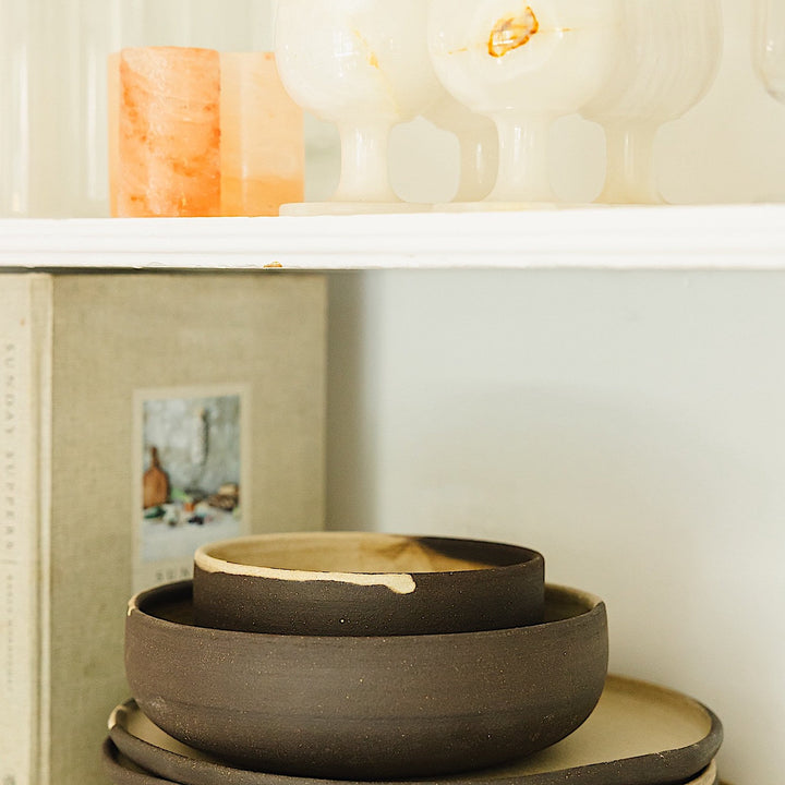 The Earl Home PLATES feature a round ceramic design with a white base and two intersecting dark blue splatter patterns. They are both dishwasher and microwave safe.