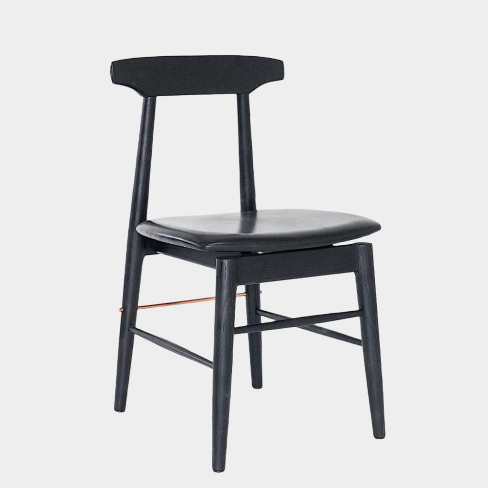 The Earl Home SABLE Dining Chair features a hand-made, black wooden design with a curved backrest and four legs. Its flat seat exemplifies minimalist elegance, crafted from solid wood for lasting durability.