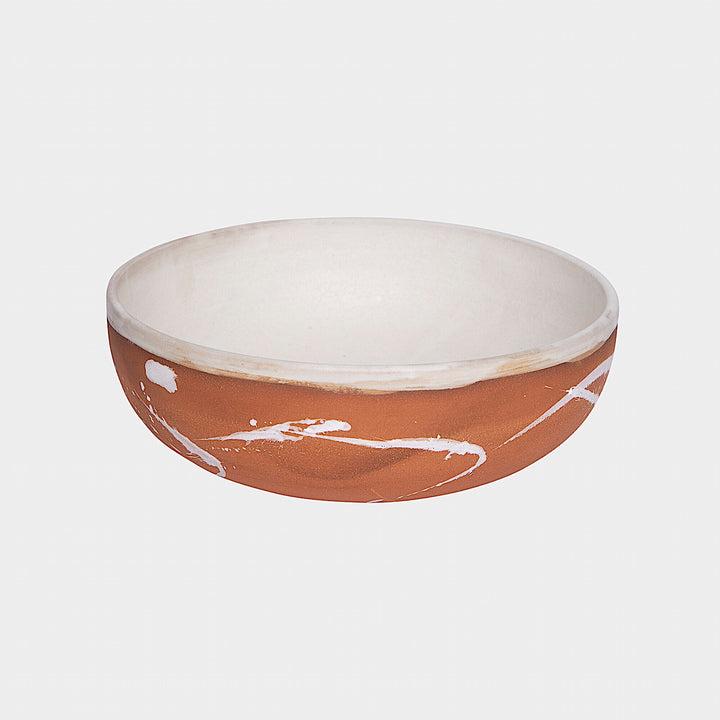 The Earl Home SERVING Bowl is a hand-thrown ceramic piece featuring a white interior and terracotta exterior with elegant swirl patterns. It is dishwasher and microwave safe.