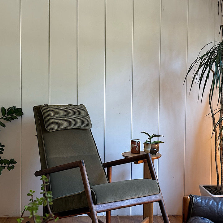 Side view of the Walnut MORESBY Rocker by Earl Home, featuring a green upholstered seat with a cushion, solid wood frame, and armrests against a white background.