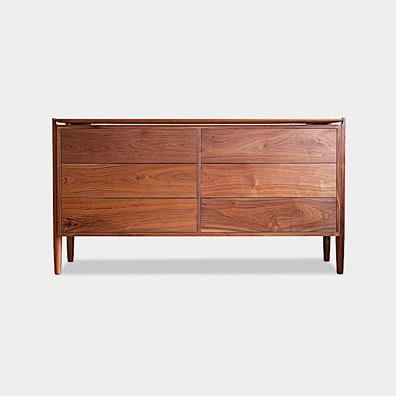 The KABOT Sideboard (Low) by Earl Home is a wooden mid-century modern dresser, featuring two woven panels and slender legs, exemplifying heritage quality design.