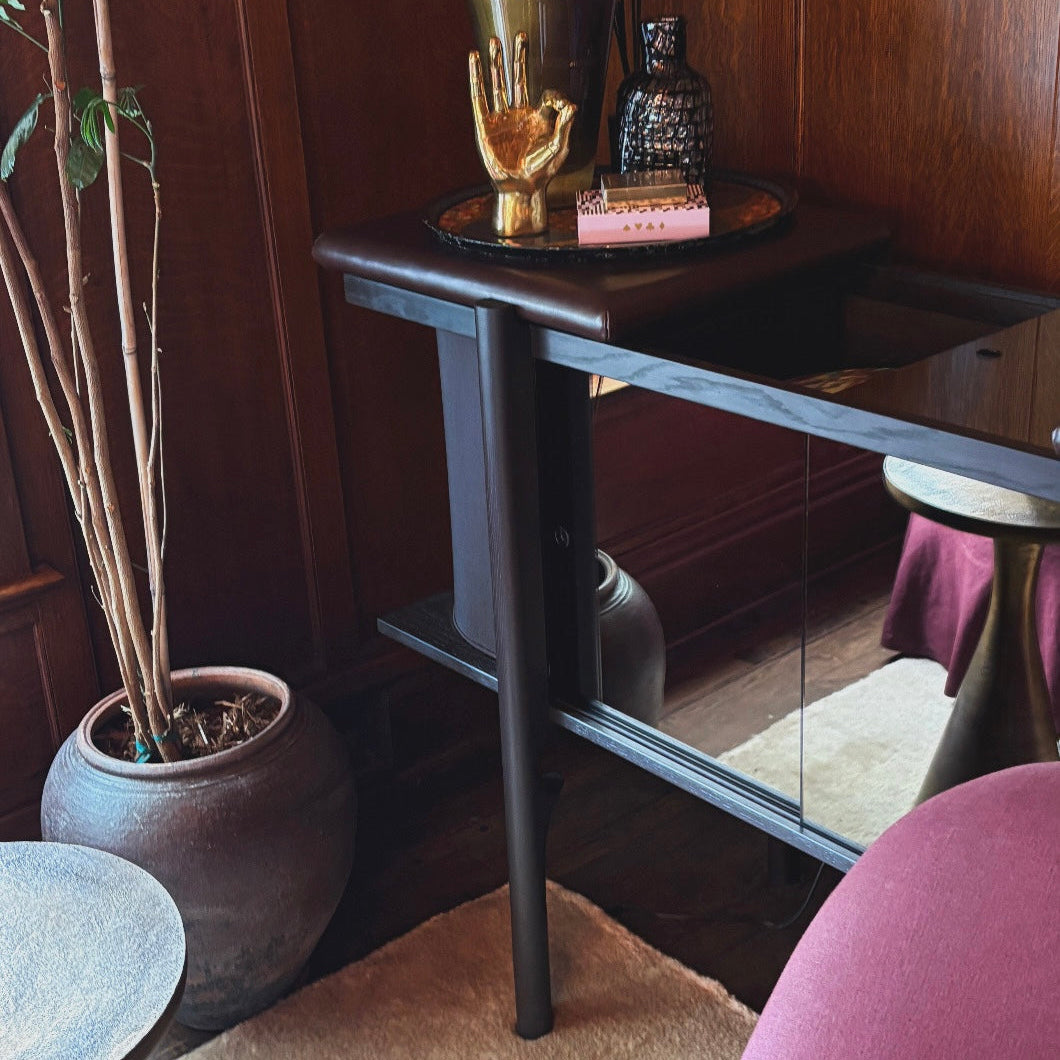 Record cabinet with decorative items against a wooden wall with a mosaic design.