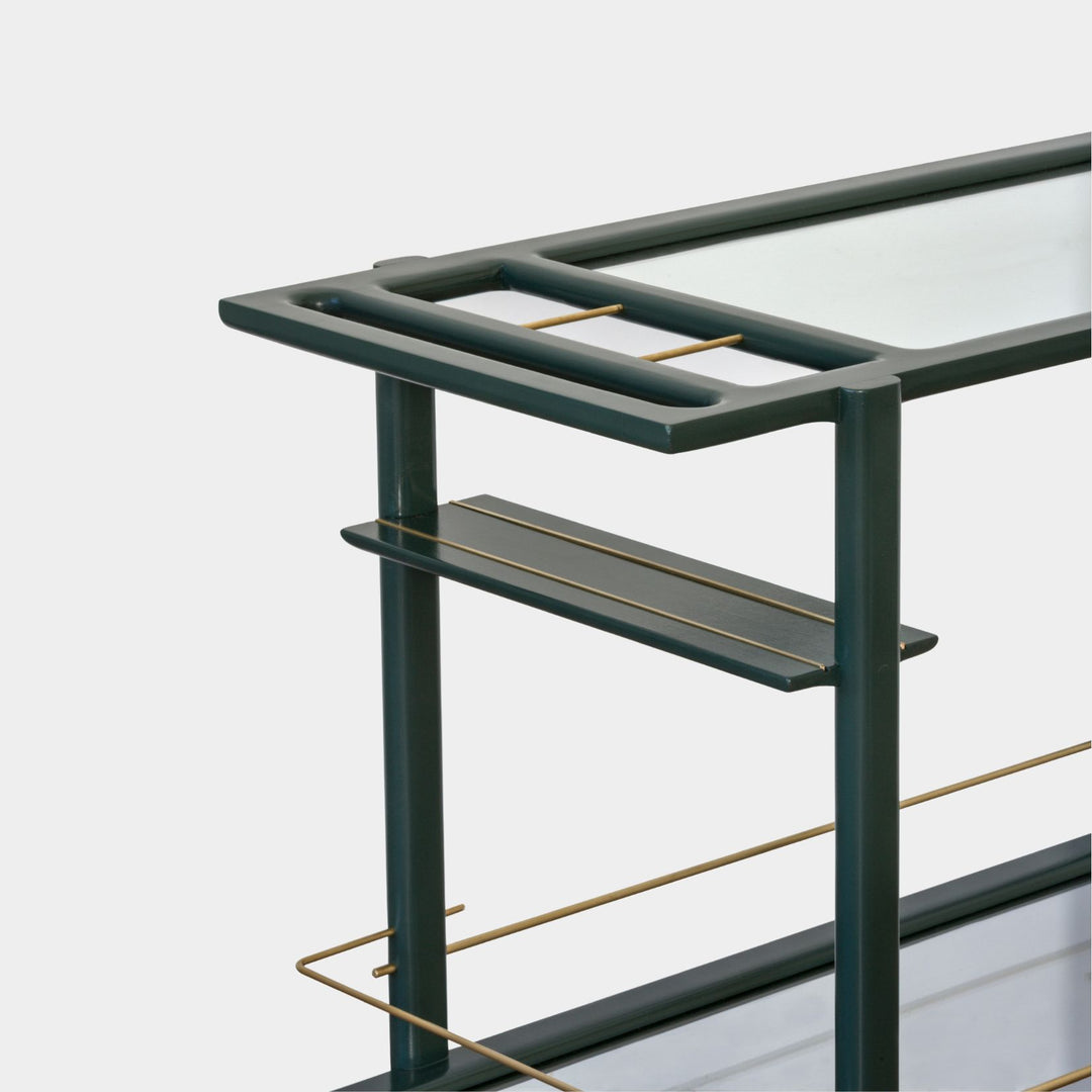 This bespoke BAR Cart from Earl Home is a custom hand made solid wood bar cart on wheels with exquisite hand-cut joinery, featuring two shelves: a robust tempered glass top and an elegant lower shelf made of clear or smoked tempered glass. This cart comes in walnut, white oak, ebonized oak, or lacquered in any pantone color. Brass, Copper and Aluminum are the metal types offered for detail.