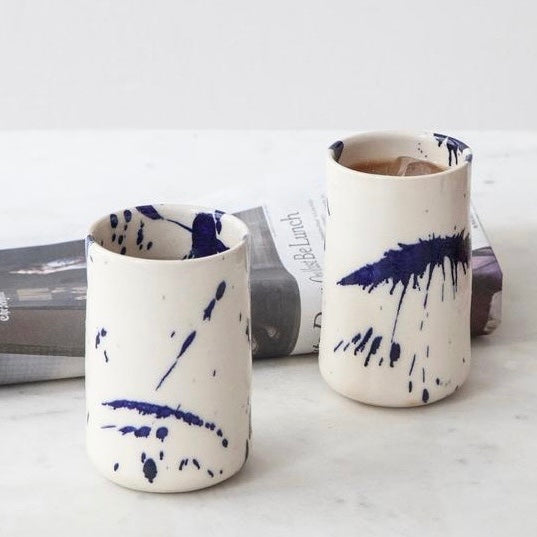 Four cylindrical cups with blue splatter abstract paint or glaze design. Hand thrown handmade pottery. Coffee Cup or mug perfect for cozy hygge morning. 