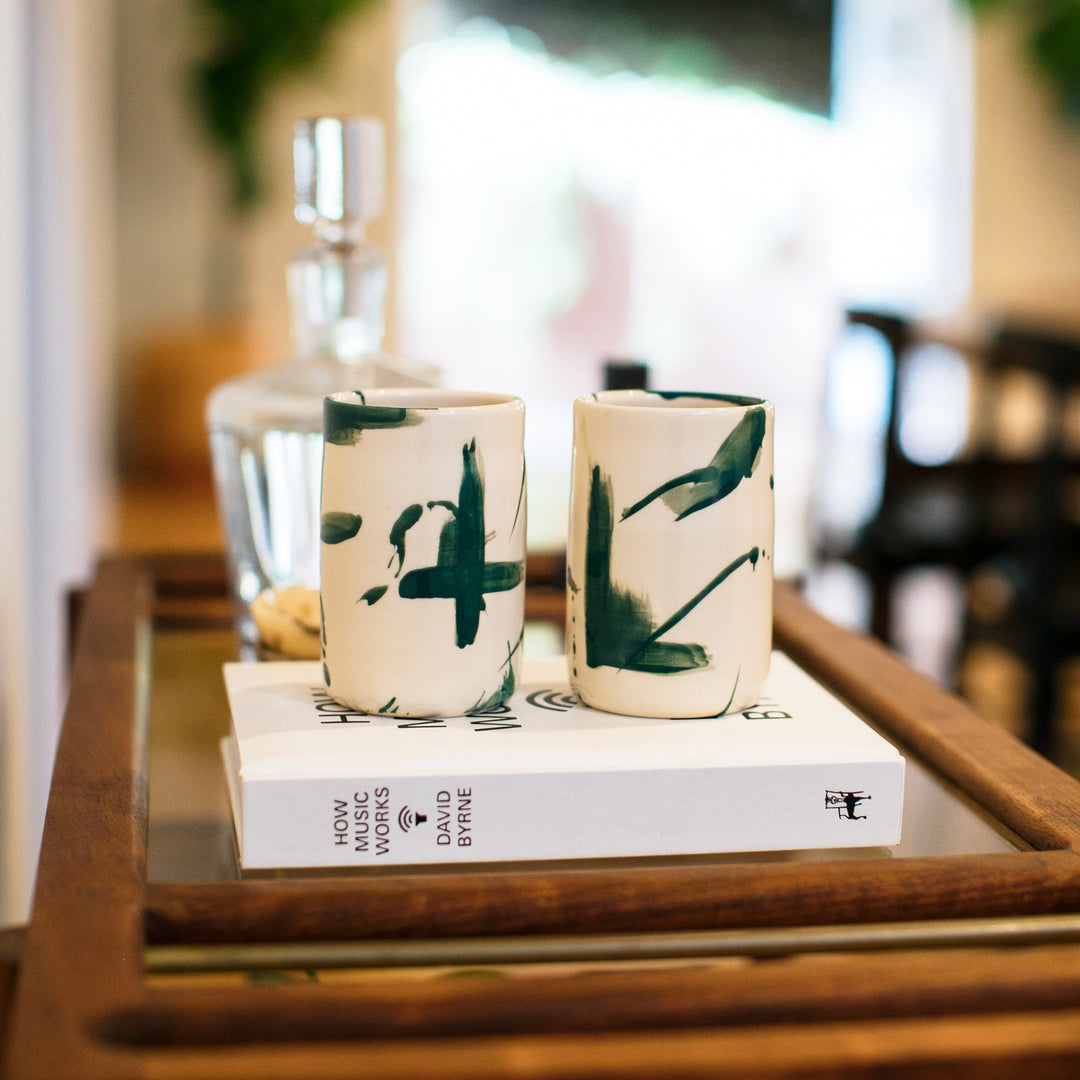 Four cylindrical cups with deep green splatter abstract paint or glaze design. Hand thrown handmade pottery. Coffee Cup or mug perfect for cozy hygge morning. 