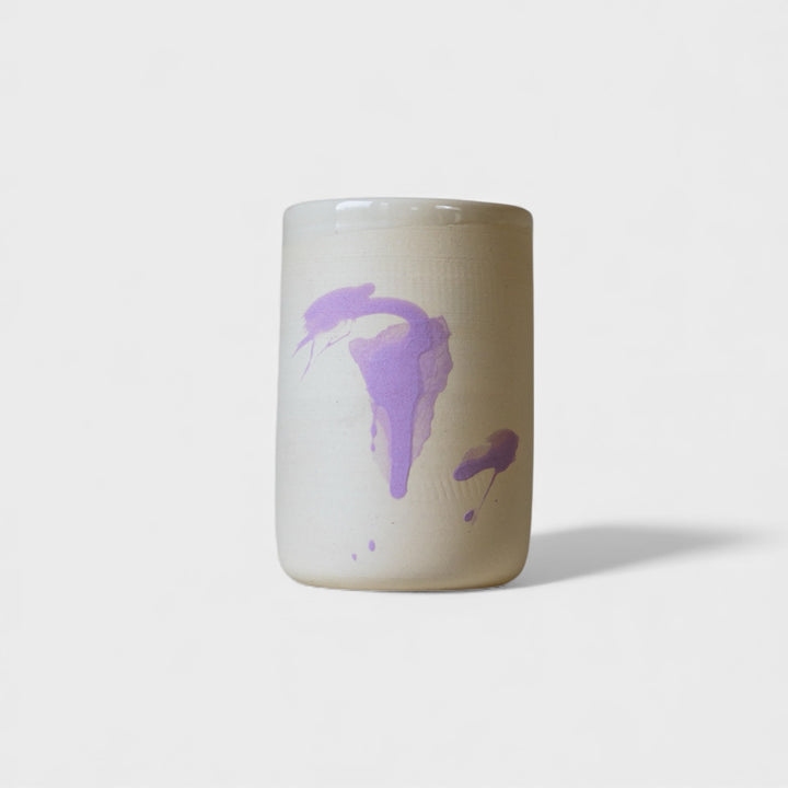 Ceramic mug with purple abstract design on a white background. Four cylindrical cups with blue splatter abstract paint or glaze design. Hand thrown handmade pottery. Coffee Cup or mug perfect for cozy hygge morning. 