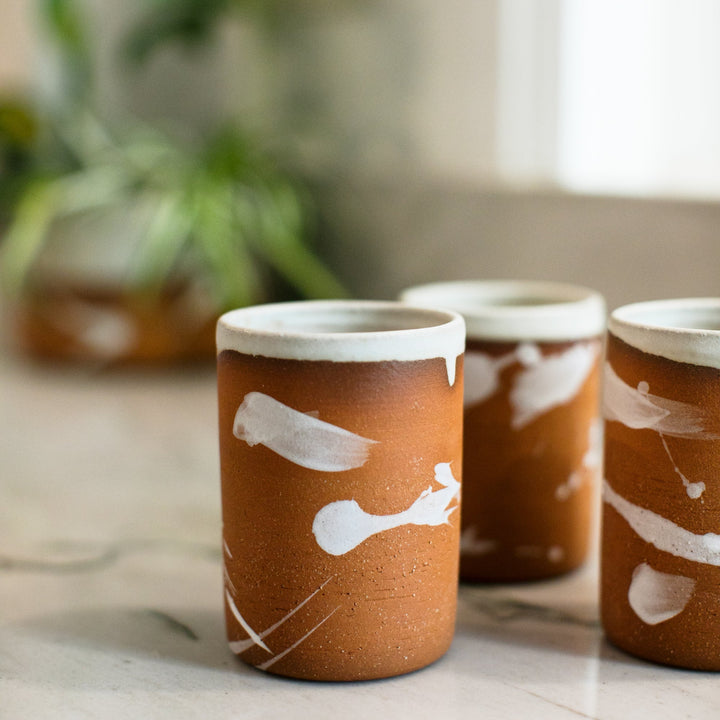 Hand made pottery, hand thrown ceramic cup with terra cotta clay and cream splattered glaze, made in Los Angeles, California.