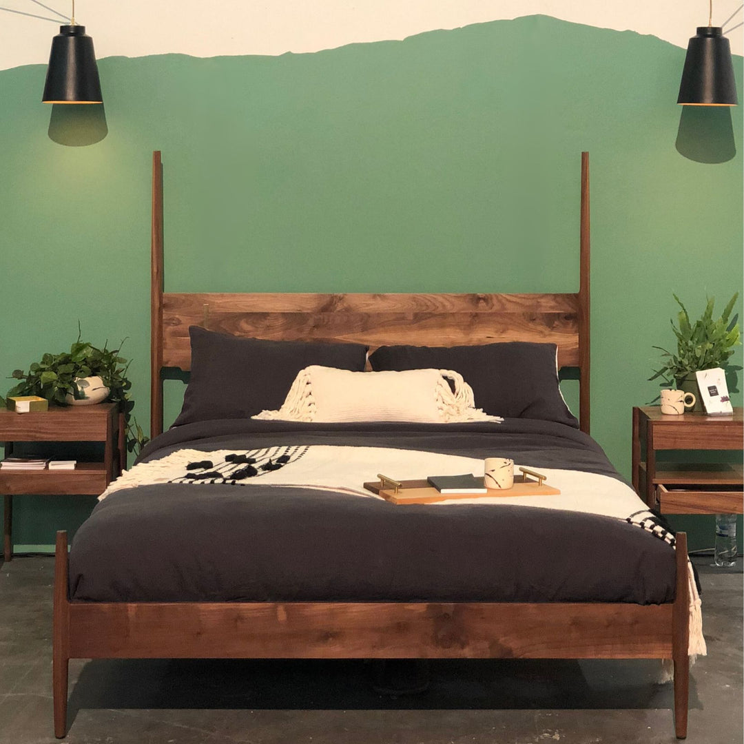 The DANSK Bed by Earl Home features a solid wood frame with a tall headboard and luxurious bedding, creating your perfect sanctuary. Crafted in walnut with maple spliced posts it exemplifies quality and is handmade to order. It is available in White oak, ebonized oak or ash. The dutchman joint can be hand cut in tonal wood, brass, copper, or aluminum.