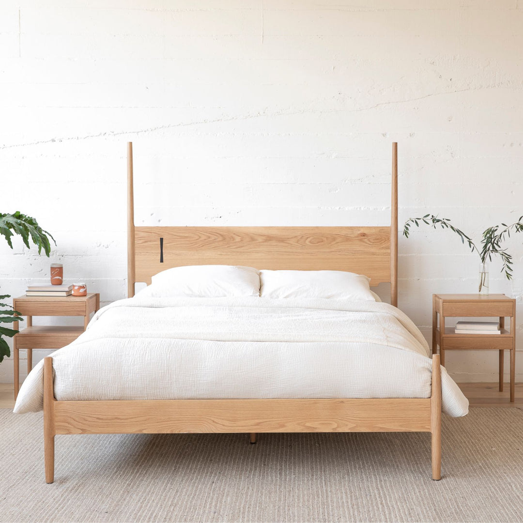 The DANSK Bed by Earl Home features a solid wood frame with a tall headboard and luxurious bedding, creating your perfect sanctuary. Originally crafted in Los Angeles, California in walnut with maple spliced posts it exemplifies quality and is handmade to order. It is available in White oak, ebonized oak or ash. The dutchman joint can be hand cut in tonal wood, brass, copper, or aluminum.