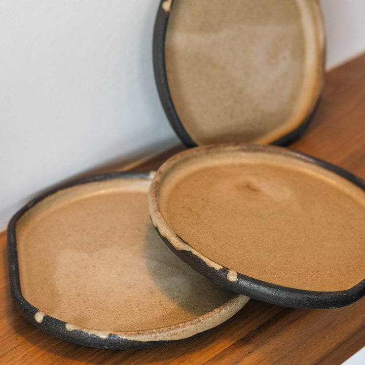 Three ceramic bowls with a textured surface on a wooden surface.