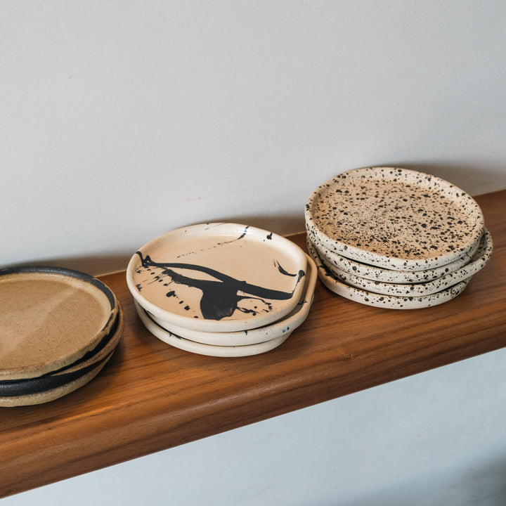 Set of ceramic plates with different designs on a wooden shelf