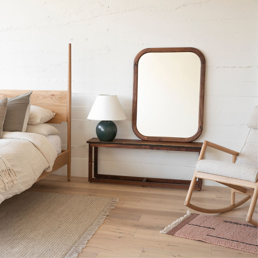 The HAROLD Mirror by Earl Home, a rectangular solid wood piece with metal inlay detailing, exquisitely reflects window light to enhance room brightness.