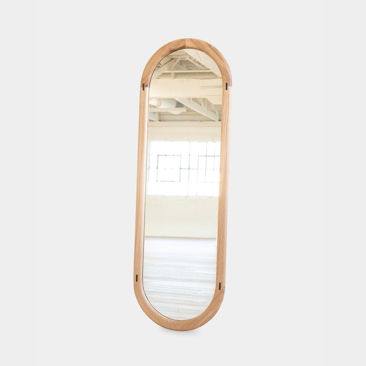 The HAROLD Mirror by Earl Home, a rectangular solid wood piece with metal inlay detailing, exquisitely reflects window light to enhance room brightness.