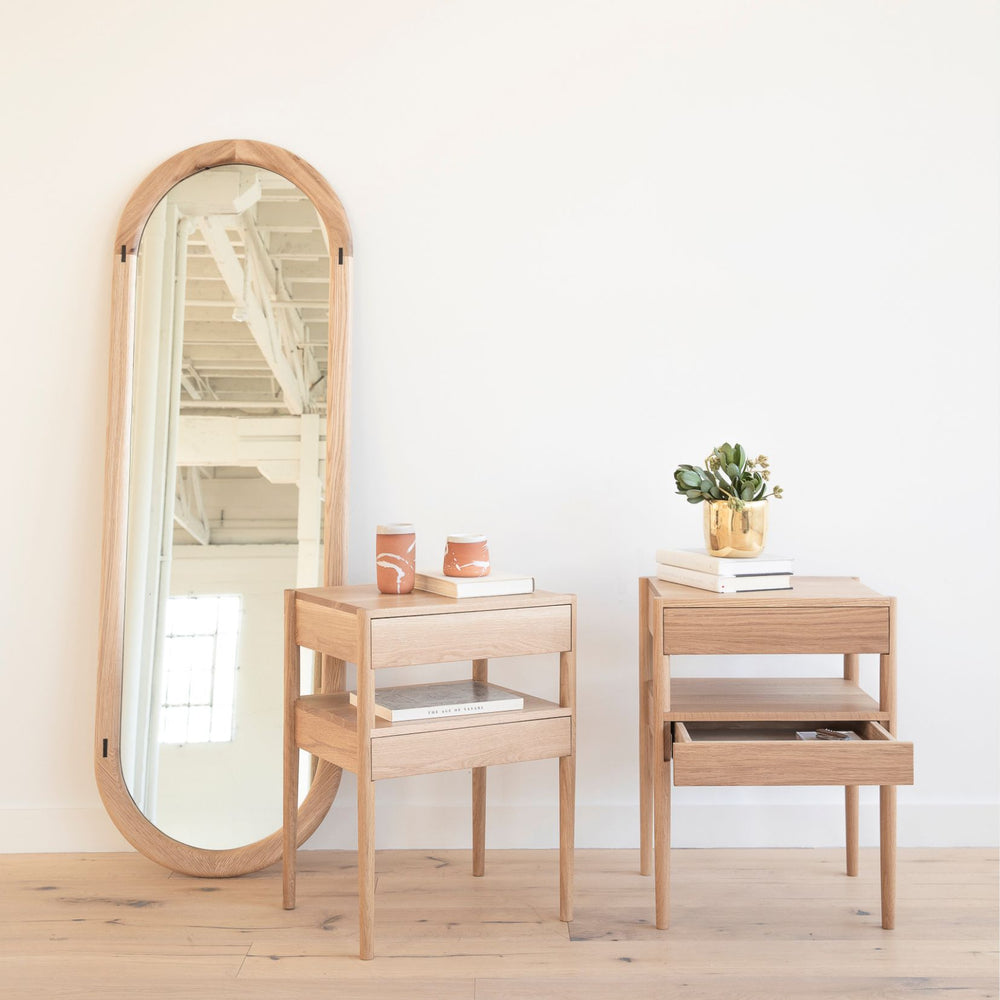 The HAROLD Mirror by Earl Home, a rectangular solid wood piece with metal inlay detailing, exquisitely reflects window light to enhance room brightness.