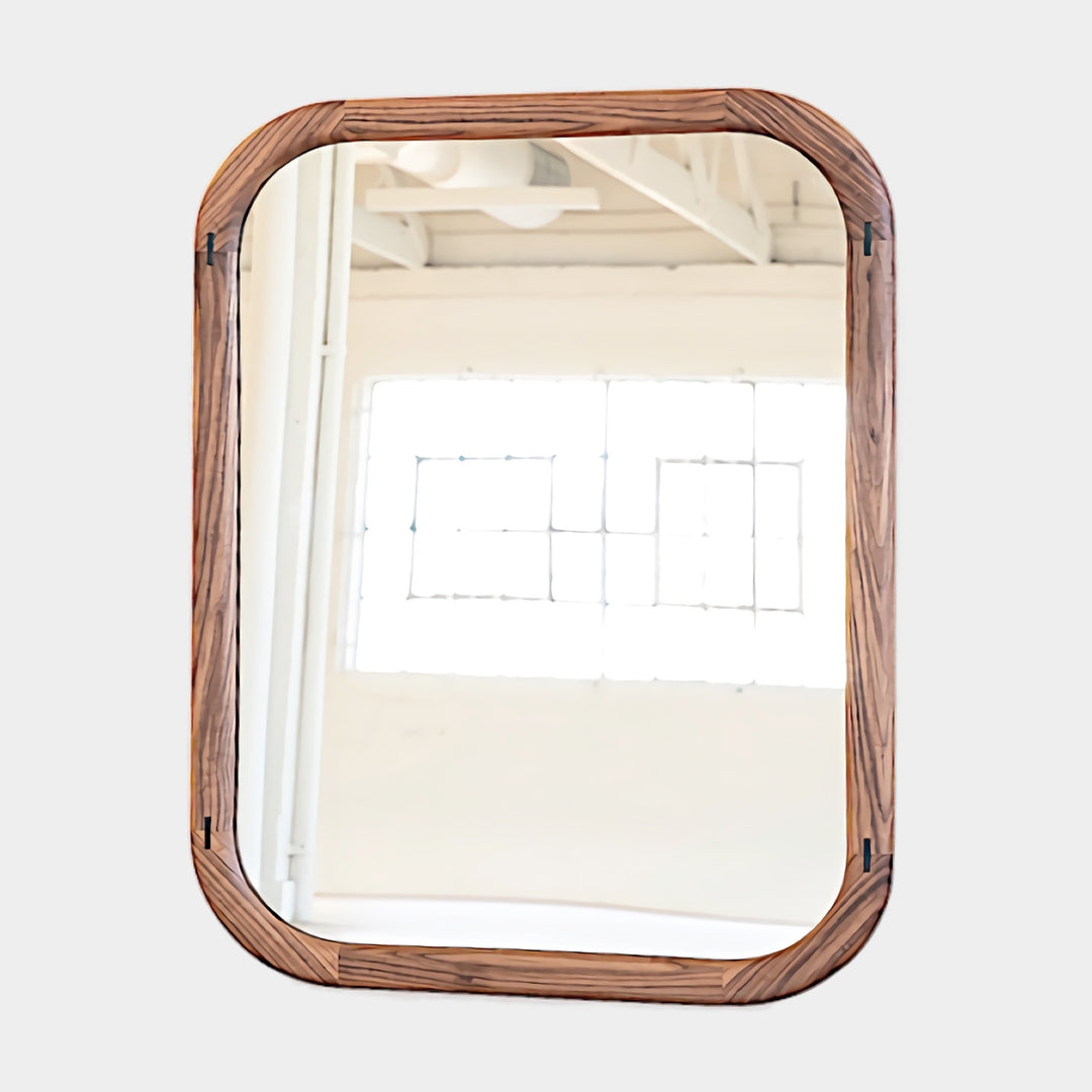 The HAROLD Mirror by Earl Home, a rectangular solid wood piece with metal inlay detailing, exquisitely reflects window light to enhance room brightness.