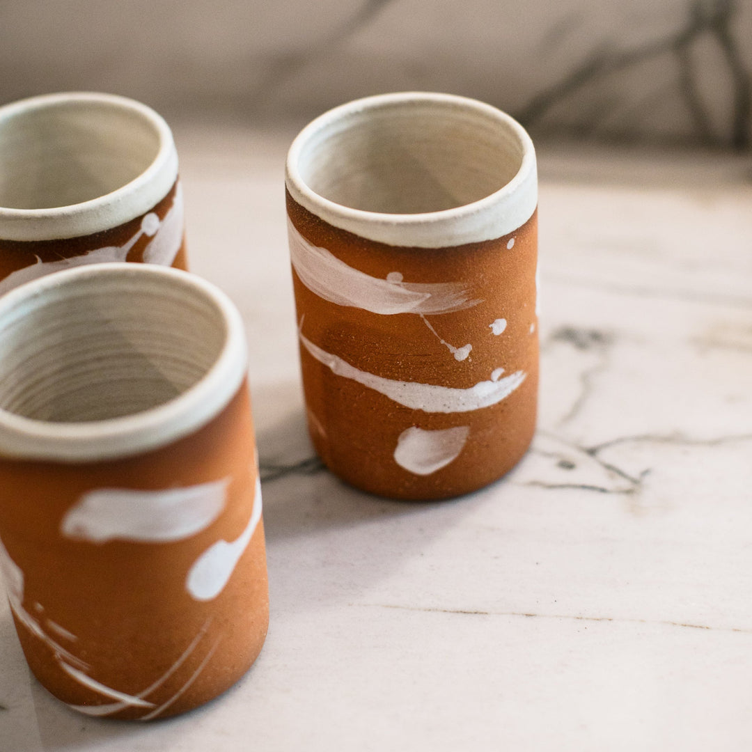 Hand made pottery, hand thrown ceramic cup with terra cotta clay and cream splattered glaze, made in Los Angeles, California.