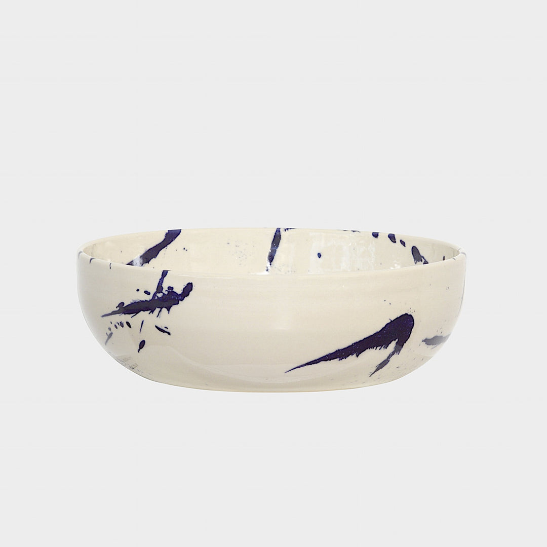 The Earl Home SERVING Bowl is a hand-thrown ceramic piece featuring a white interior and terracotta exterior with elegant swirl patterns. It is dishwasher and microwave safe.