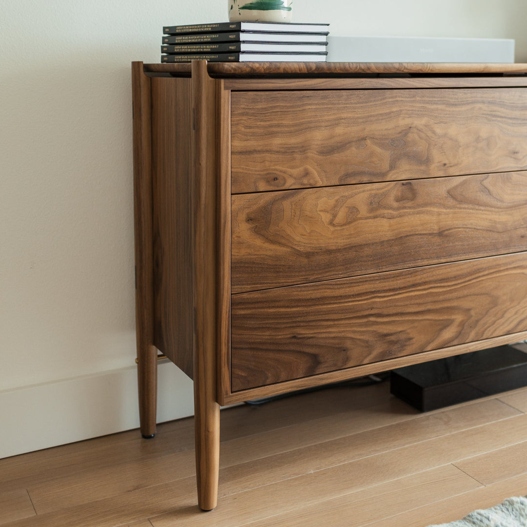 Timeless wooden walnut dresser with a floating top and solid wood construction with handcut joinery. Push to open and slow closing drawers. No hardware makes for a sleek and simple design. 