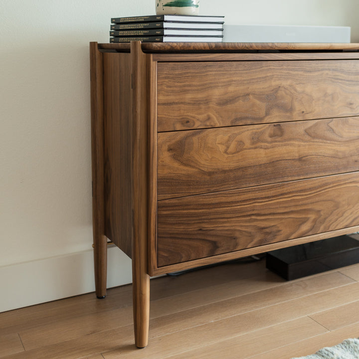 Timeless wooden walnut dresser with a floating top and solid wood construction with handcut joinery. Push to open and slow closing drawers. No hardware makes for a sleek and simple design. 