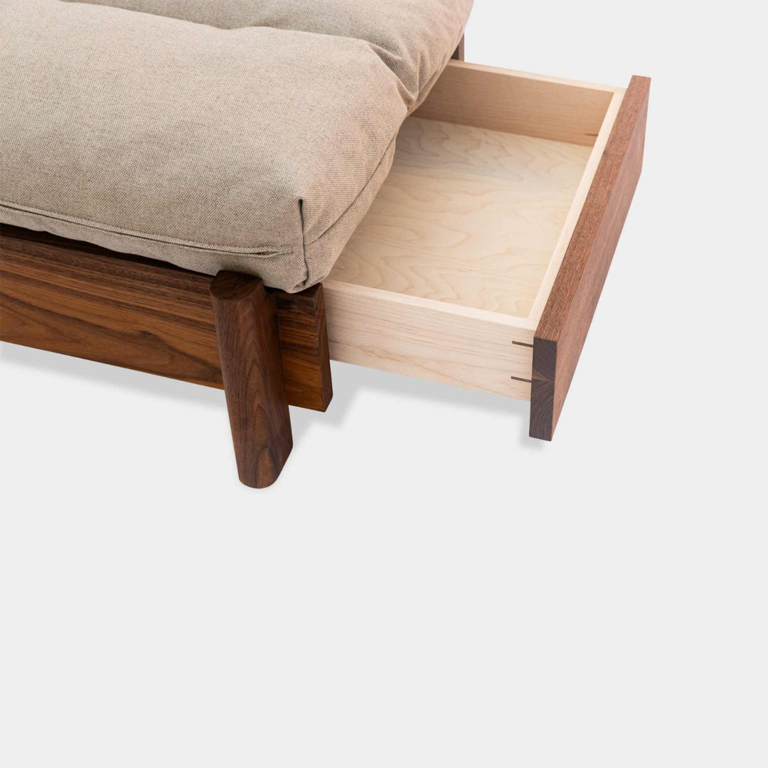 This EARL handmade dog bed has a solid wood base with a hidden drawer, and a custom detachable cushion upholstered in Sunbrella Blend Sand. We offer various fabrics and customers own fabric is encouraged as well. The base can be made in walnut, white oak, or ebonized oak and custom sizing is also available.