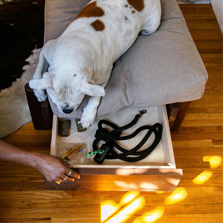 This EARL handmade dog bed has a solid wood base with a hidden drawer, and a custom detachable cushion upholstered in Sunbrella Blend Sand. We offer various fabrics and customers own fabric is encouraged as well. The base can be made in walnut, white oak, or ebonized oak and custom sizing is also available.