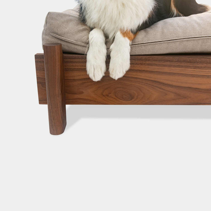 This EARL handmade dog bed has a solid wood base with a hidden drawer, and a custom detachable cushion upholstered in Sunbrella Blend Sand. We offer various fabrics and customers own fabric is encouraged as well. The base can be made in walnut, white oak, or ebonized oak and custom sizing is also available.